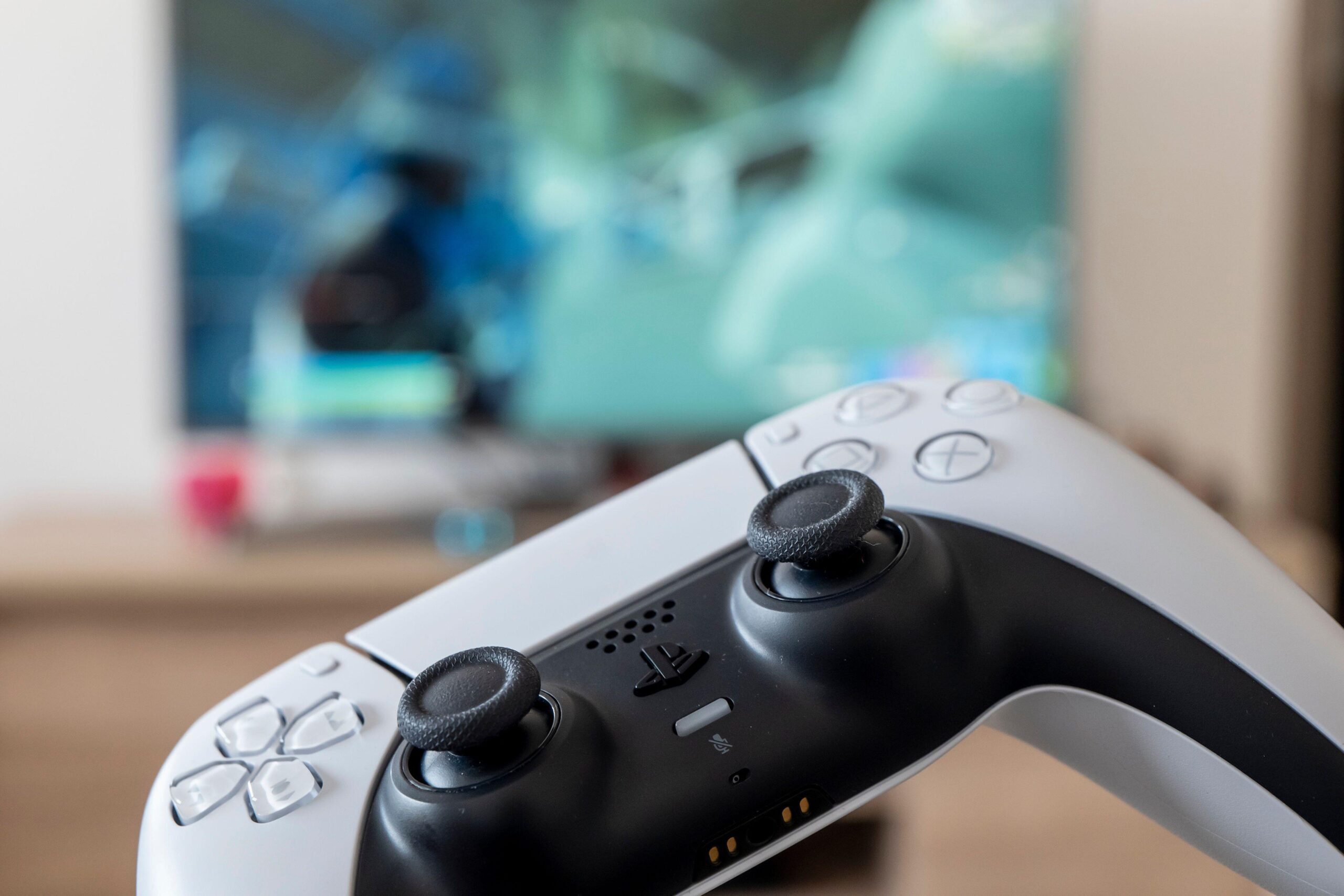 a person holding a white PS 5 controller with a video game on screen to represent the hype for Lost Soul Aside coming in August
