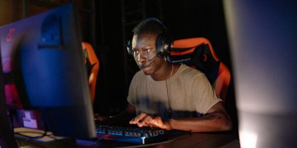 a person sitting in a dark room in front of their PC playing Hell Let Loose